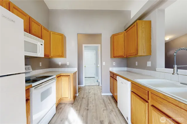 a kitchen with stainless steel appliances granite countertop wooden cabinets a stove a sink and a refrigerator