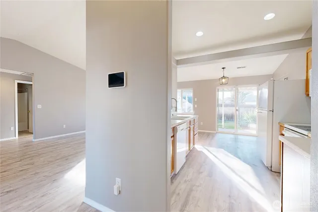 a view of an empty room with window and wooden floor