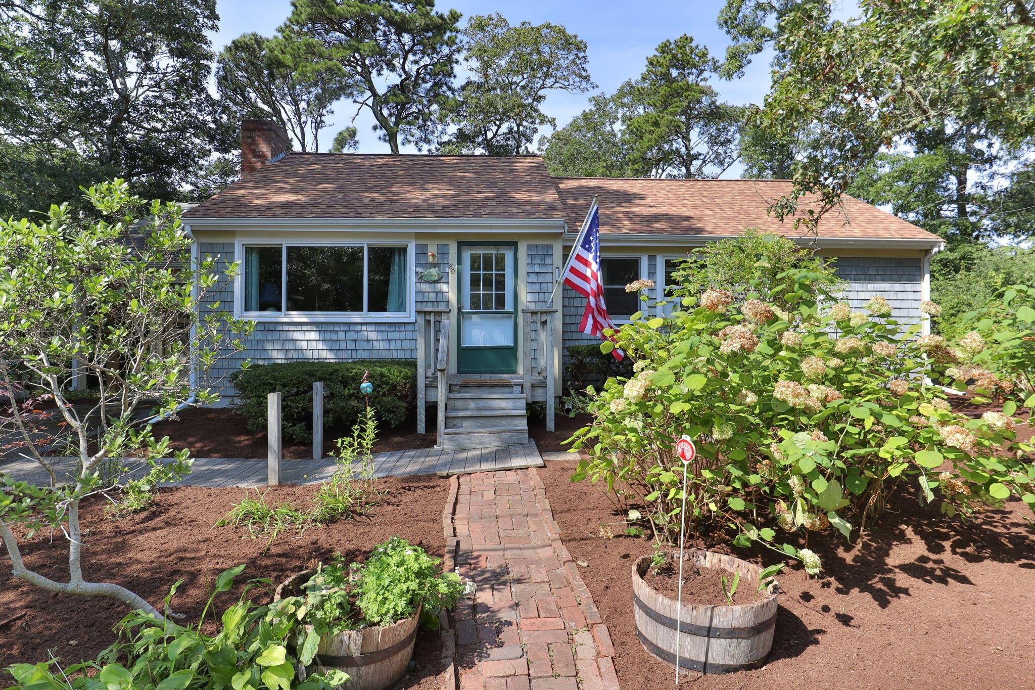 80 Prell Circle Brewster, MA 02631 - Photo 2 of 34 a front view of a house with a garden and plants