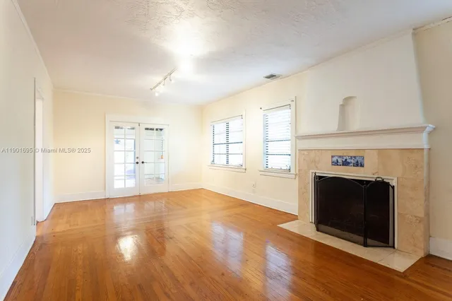 a view of an empty room with a fireplace and a window
