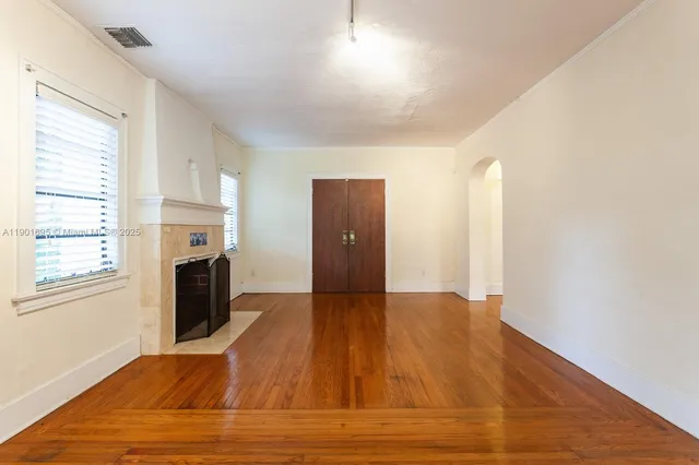 a view of an empty room with a fireplace and a window