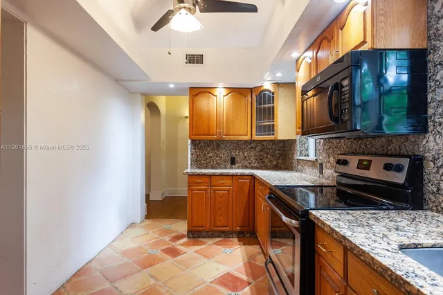 a kitchen with stainless steel appliances granite countertop a stove a sink and a microwave