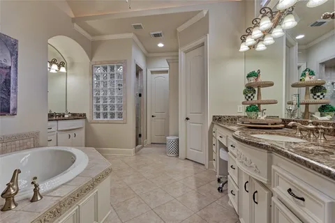 a spacious bathroom with a granite countertop sink a mirror and a bathtub