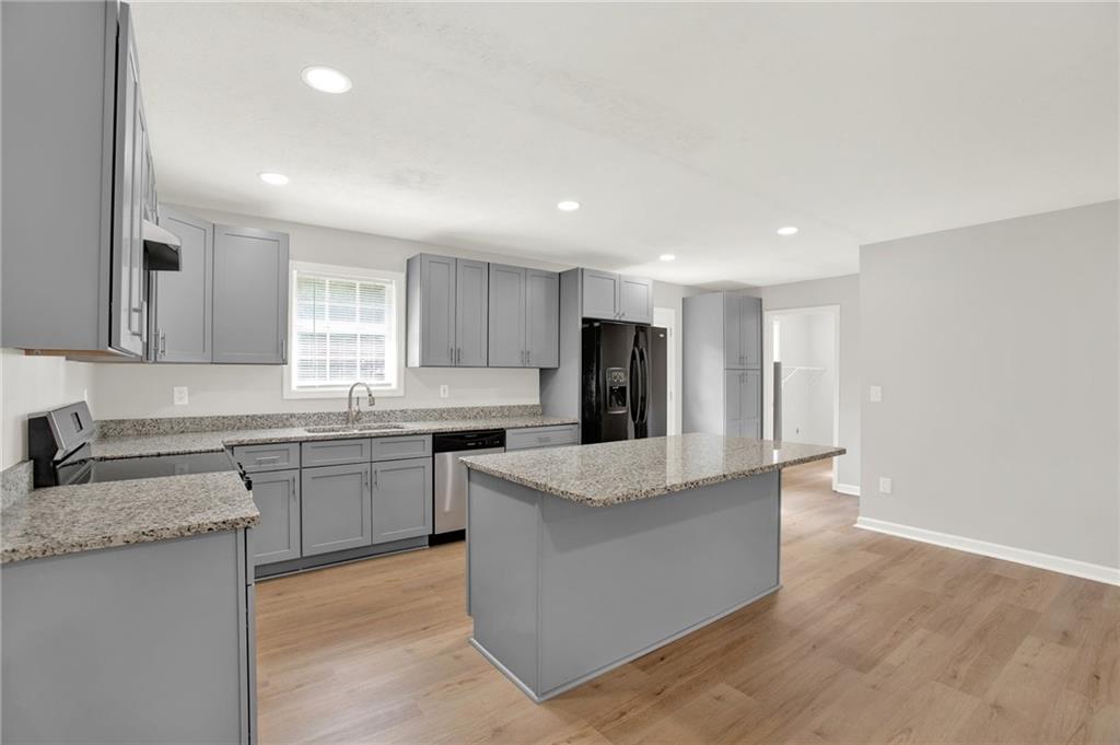 76 Picklesimer Road Southwest Cartersville, GA 30120 - Photo 10 of 43 a large kitchen with stainless steel appliances granite countertop a large counter top a stove a sink dishwasher and a refrigerator with wooden floor