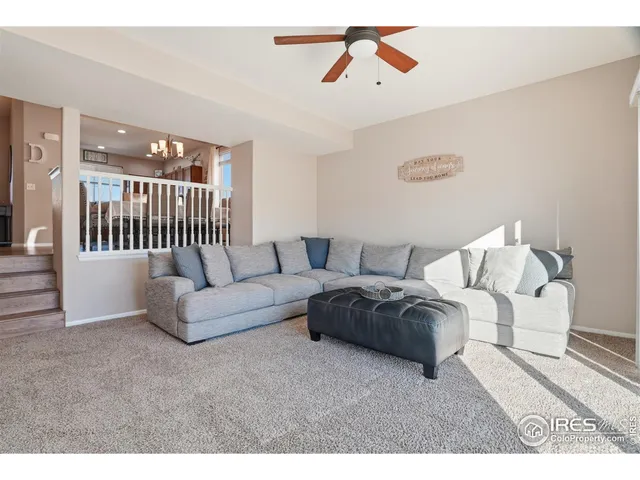 a living room with furniture and a ceiling fan