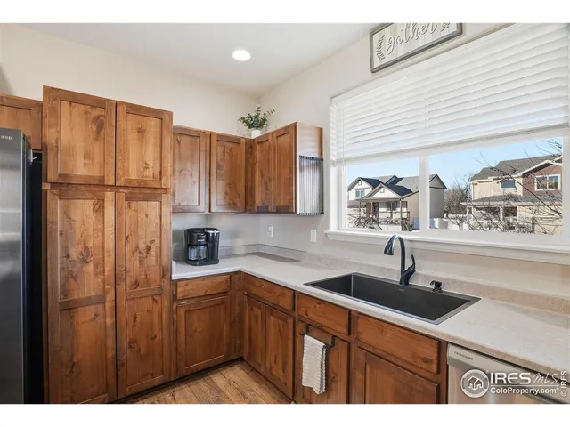 a kitchen with stainless steel appliances a sink cabinets and a window