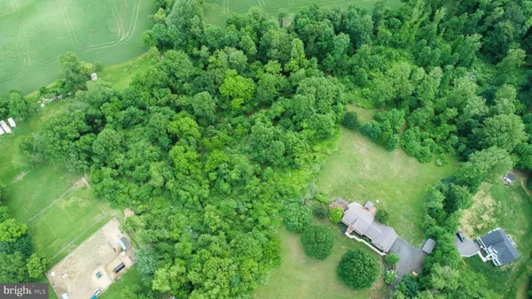 an aerial view of residential house with outdoor space and trees around