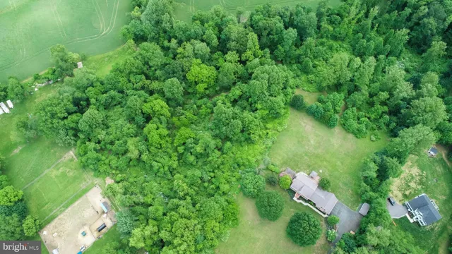an aerial view of residential house with outdoor space and trees around