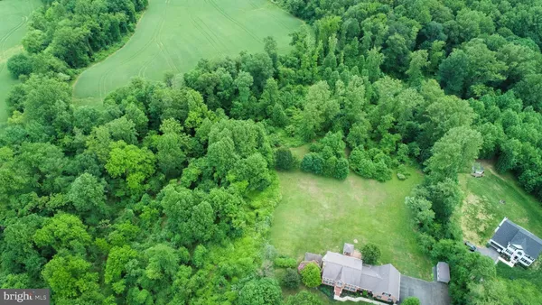 an aerial view of residential house with outdoor space and trees around