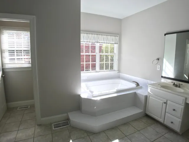 a bathroom with a tub sink and window