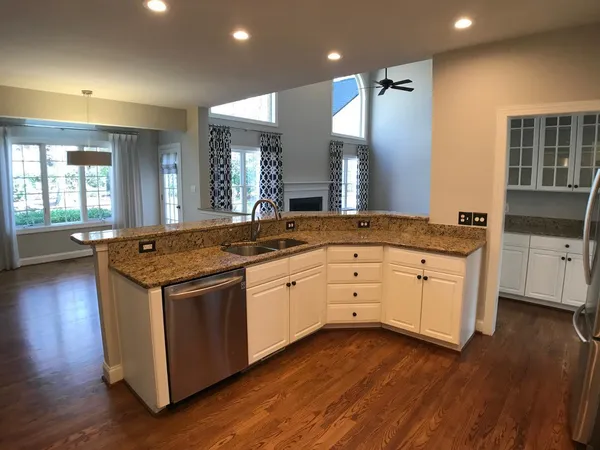 a kitchen with stainless steel appliances granite countertop wooden floors and view living room