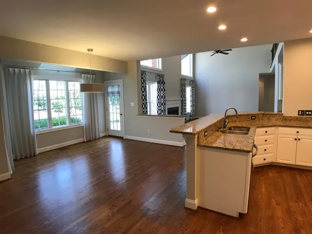a kitchen with stainless steel appliances granite countertop a stove and a wooden floors