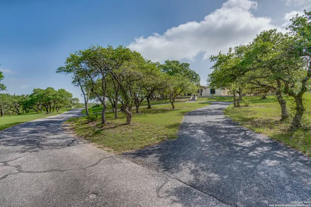 an empty room with wooden floor fireplace and windows