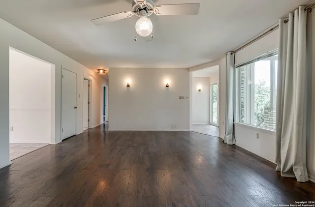 a kitchen with white cabinets and window