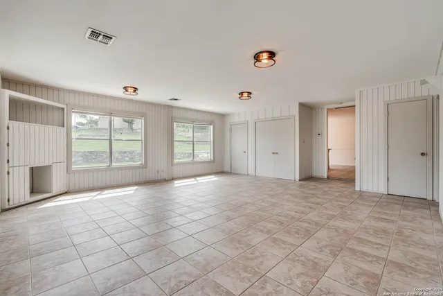 a view of an empty room with a fireplace and a window
