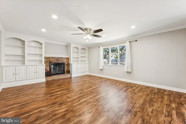a view of empty room with wooden floor and fireplace