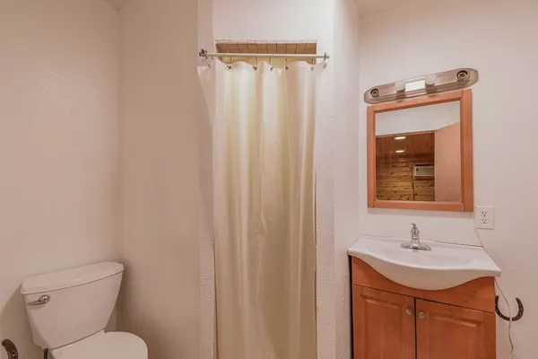 a bathroom with a toilet sink and mirror