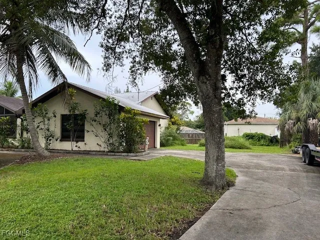 a front view of a house with a yard and trees
