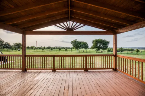 a view of a porch with wooden floor and fence