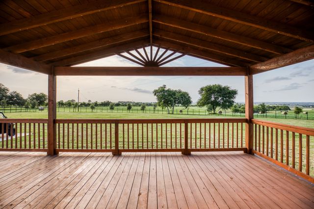 a view of a porch with wooden floor and fence