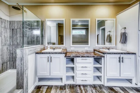 a large bathroom with a tub a double vanity sink and a large mirror