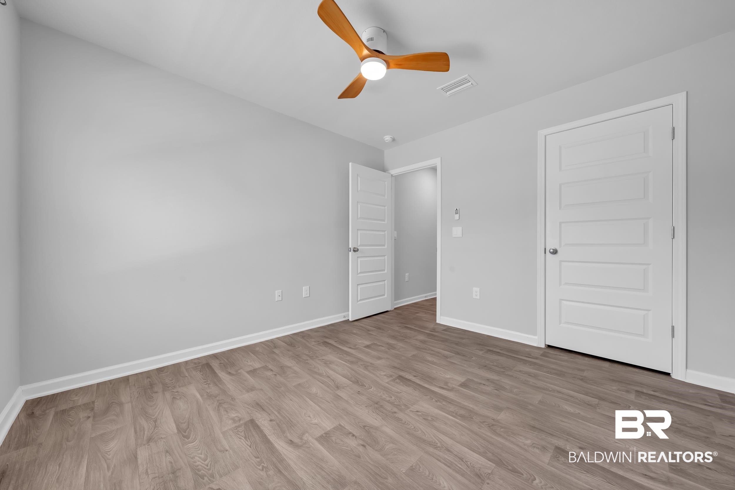 3070 Camino Real Loop Lillian, AL 36549 - Photo 29 of 46 Neutral gray walls with white trim and wood-finish flooring