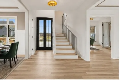 a view of a hallway with wooden floor and furniture