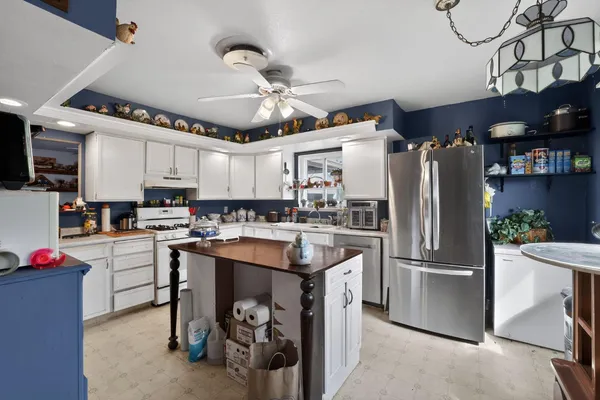a kitchen with refrigerator and cabinets