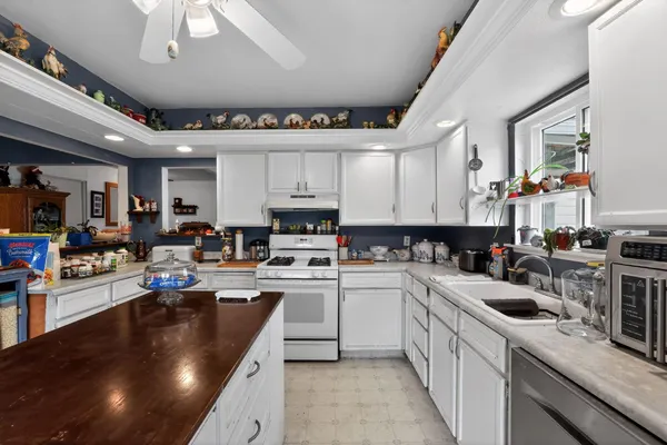 a kitchen with a sink a counter top space appliances and cabinets