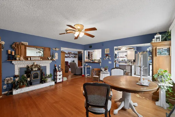 a dining room with furniture potted plants and wooden floor