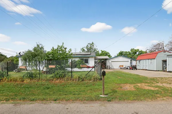 a front view of a house with a yard and trees