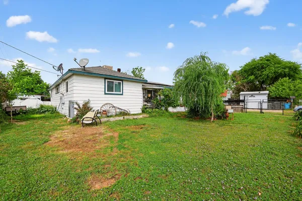 a view of a house with backyard and sitting area