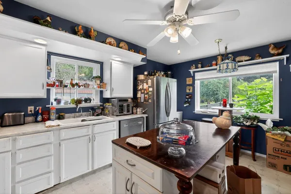 a kitchen with stainless steel appliances granite countertop a stove refrigerator a sink dishwasher and a dining table with the kitchen view