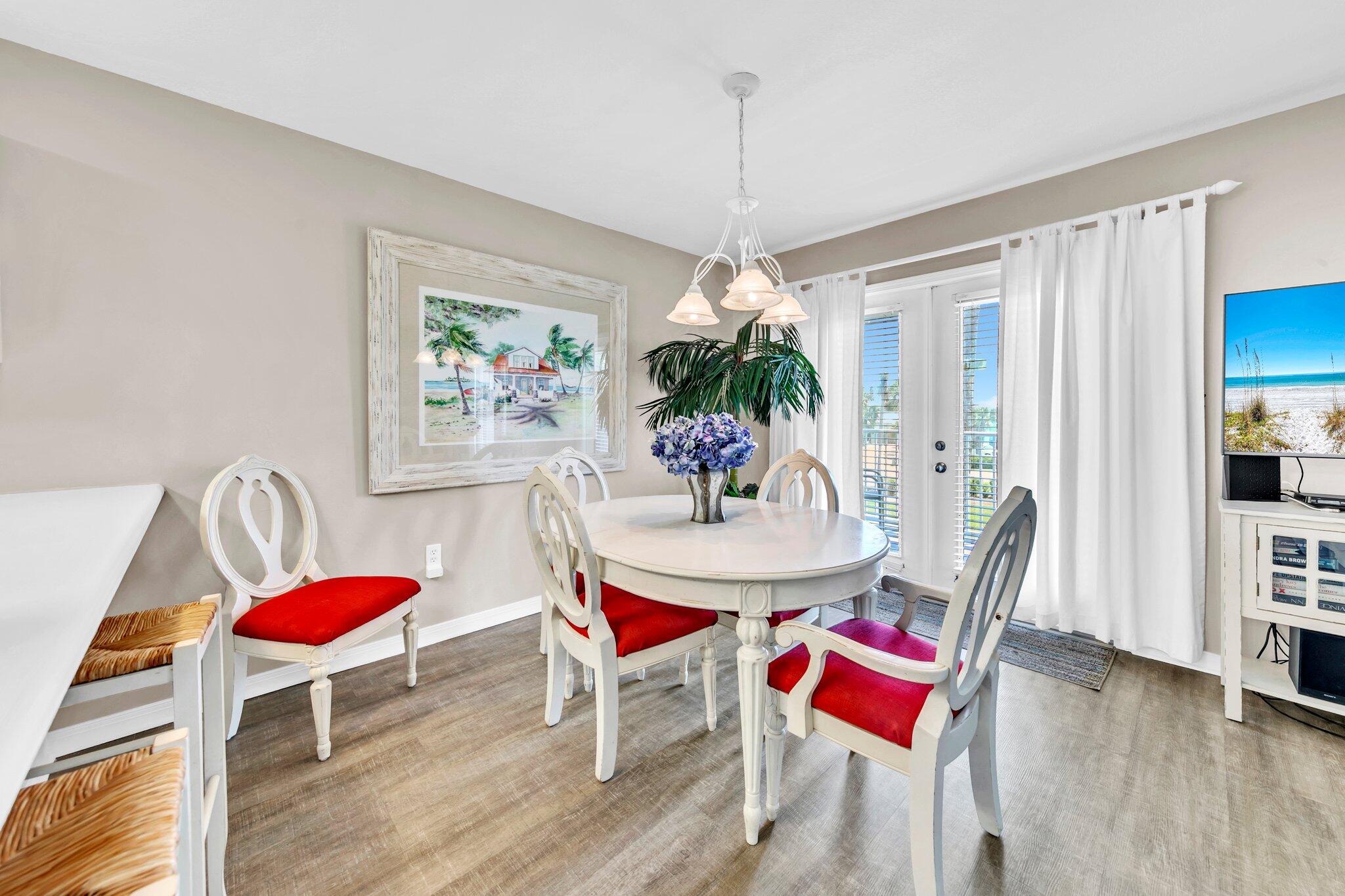 144 Spires Lane, Unit 202 Santa Rosa Beach, FL 32459 - Photo 14 of 31 a dining room with furniture a rug a potted plant and wooden floor