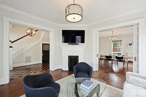 a living room with furniture a flat screen tv and kitchen view