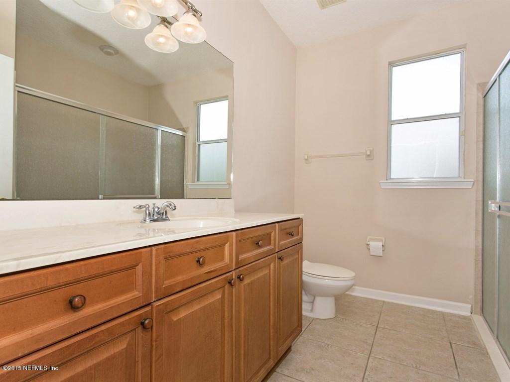 2048 River's Own Road St. Augustine, FL 32092 - Photo 17 of 38 a bathroom with a sink a toilet a mirror and vanity