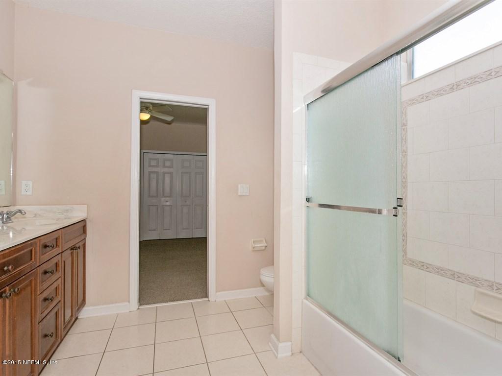 2048 River's Own Road St. Augustine, FL 32092 - Photo 19 of 38 a spacious bathroom with a granite countertop sink a mirror and a bathtub
