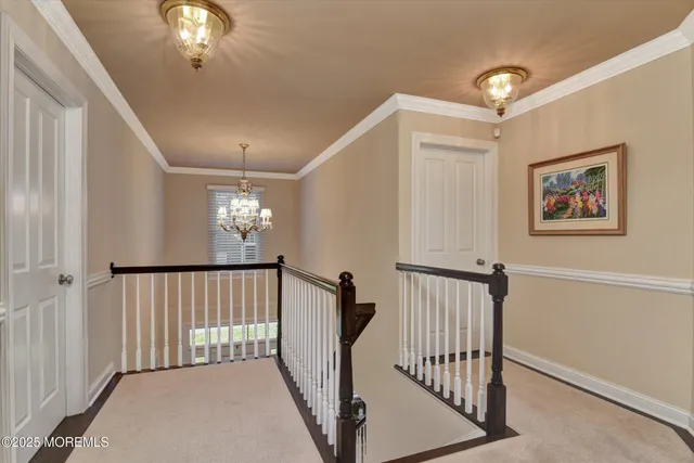 a view of staircase with railing and a chandelier