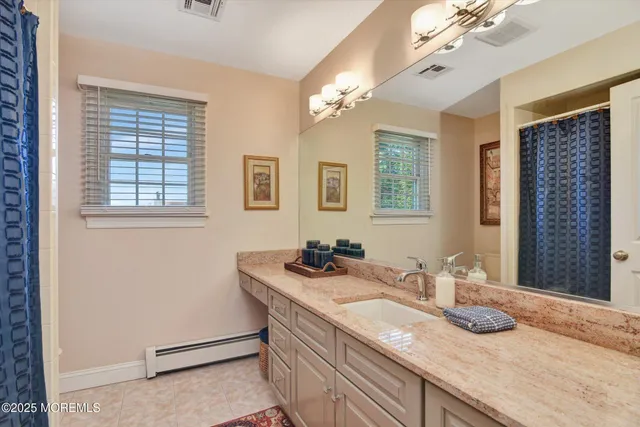 a bathroom with a granite countertop sink a large mirror and a shower
