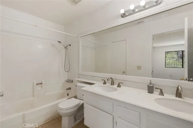 a bathroom with a double vanity sink toilet and shower