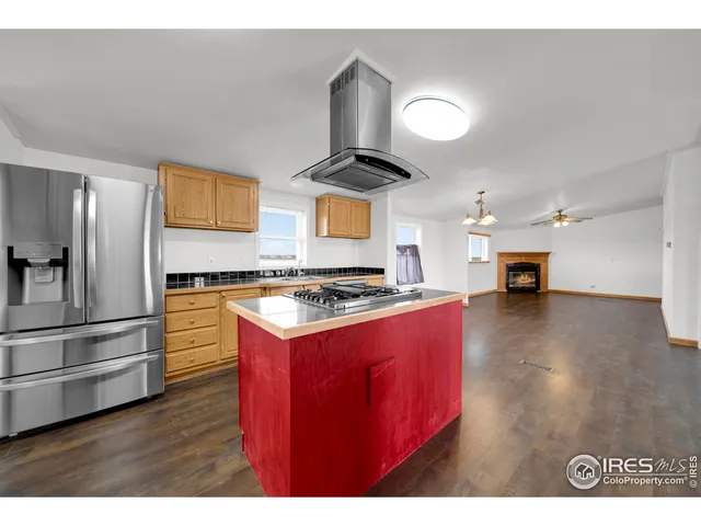 a kitchen with stainless steel appliances granite countertop a stove a refrigerator a sink and a wooden floors