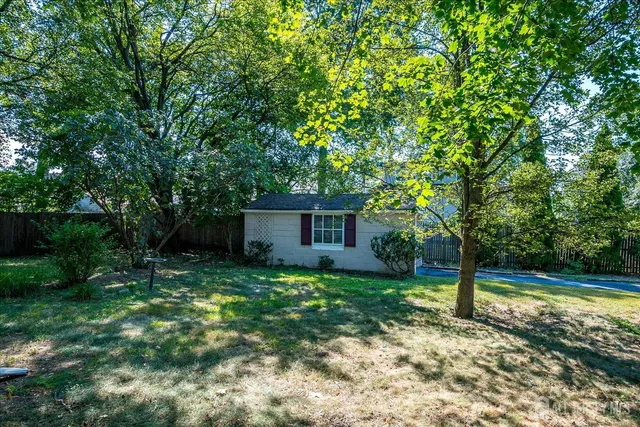 a view of backyard with swimming pool and seating space