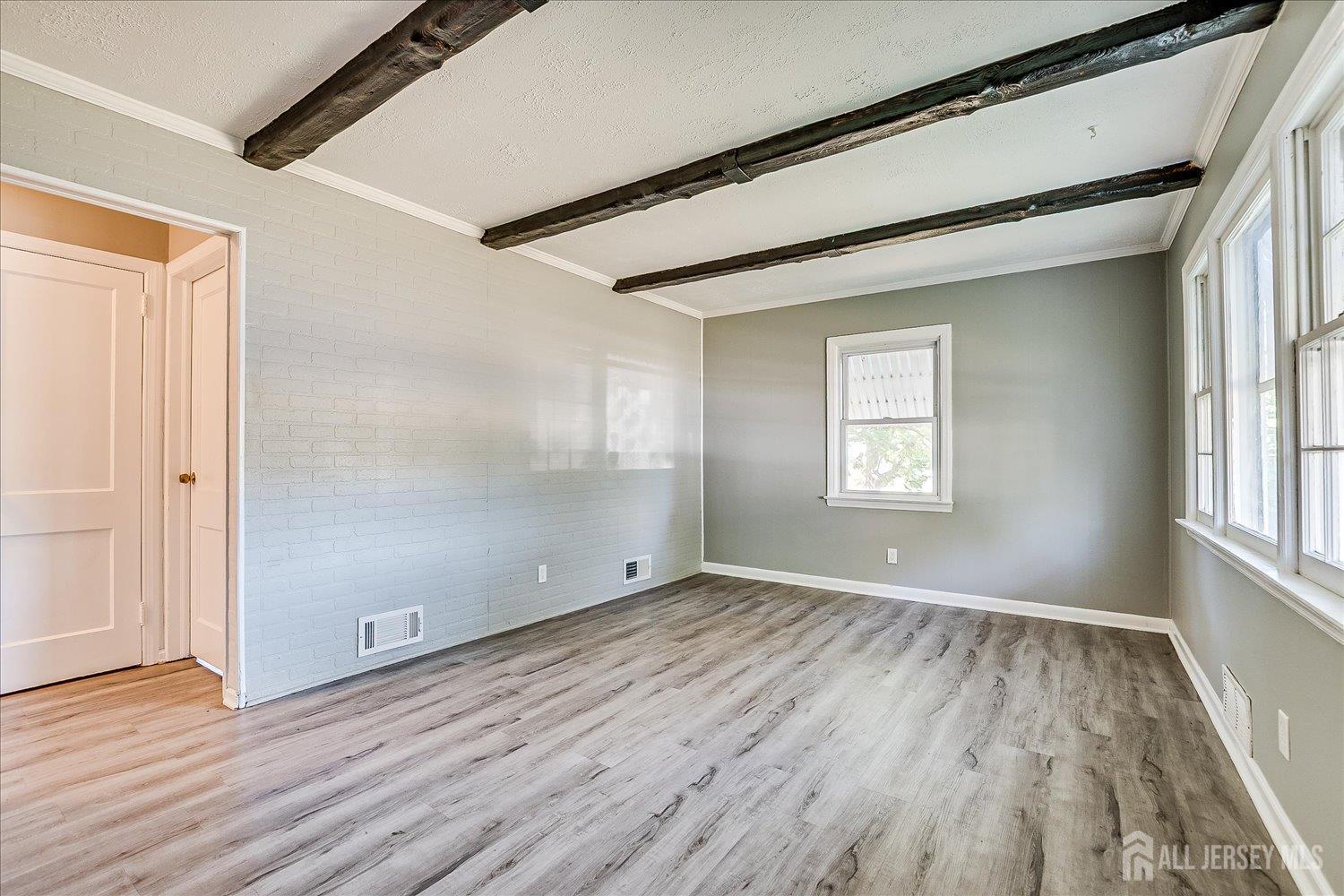 310 Howard Avenue Middlesex, NJ 08846 - Photo 10 of 42 an empty room with wooden floor and windows