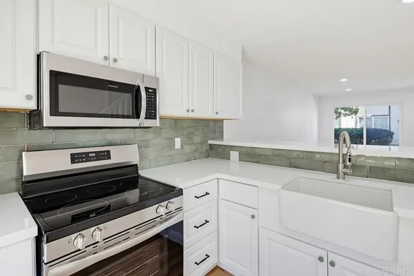 a kitchen with granite countertop a stove microwave and sink
