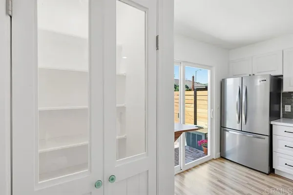 a kitchen with a refrigerator and wooden floor