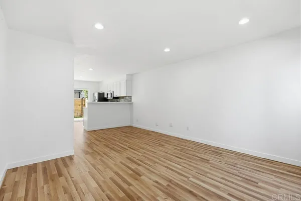 a view of a kitchen with wooden floor and a ceiling fan