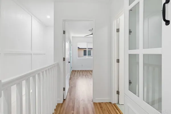 a view of a hallway with wooden floor and staircase