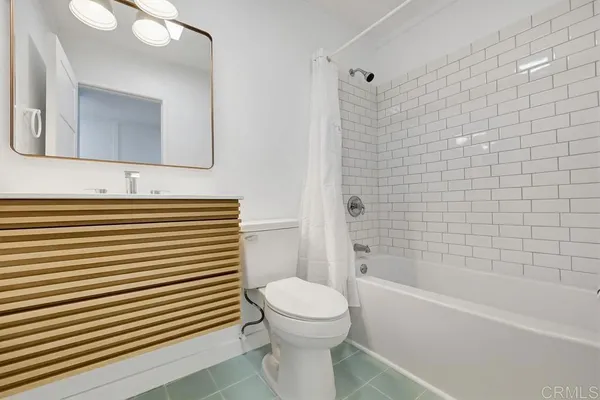 a bathroom with a bathtub a sink a toilet and a mirror