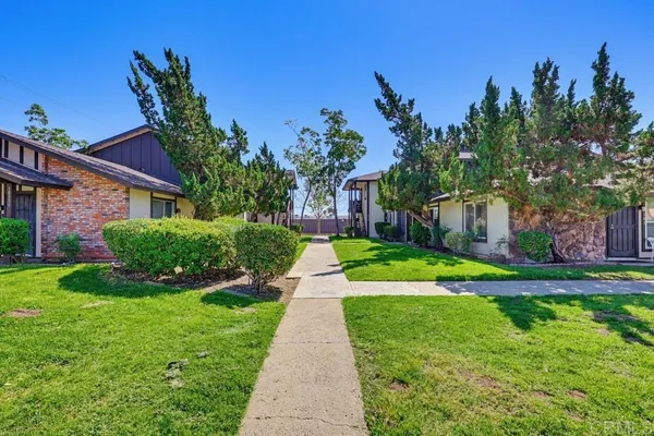 a front view of a house with a yard and potted plants