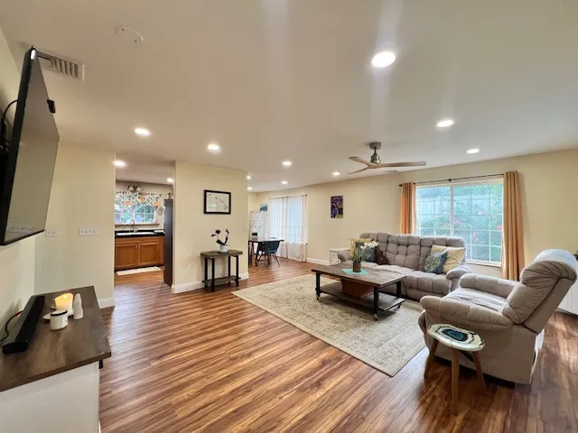 a living room with furniture and a wooden floor